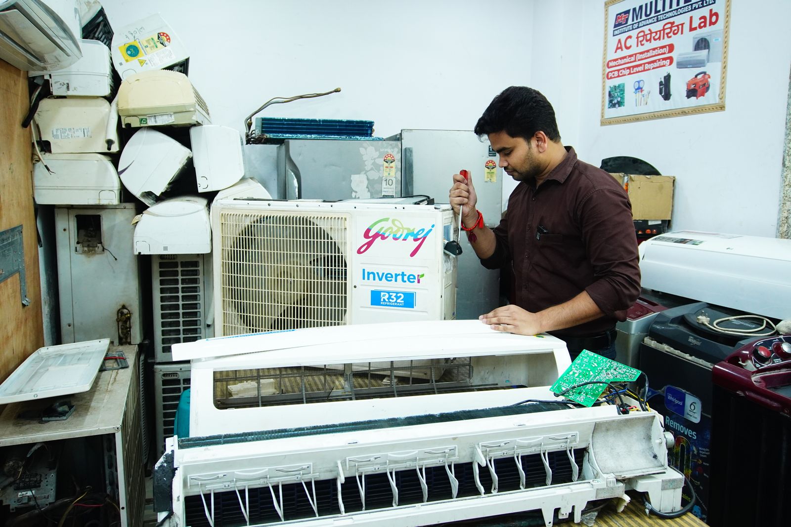 South Asian HVAC technician repairing an air conditioning system